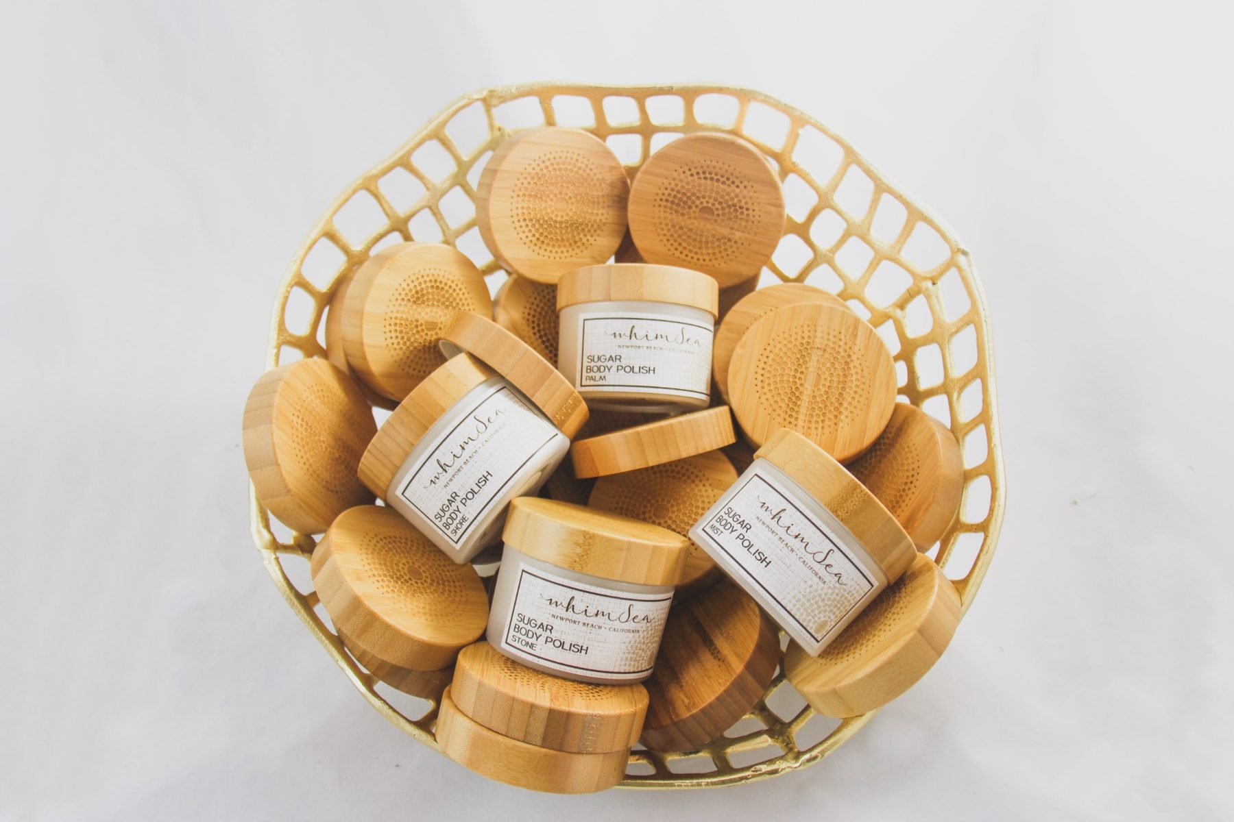 Overhead shot of WhimSea jars and bamboo lids in a gold basket